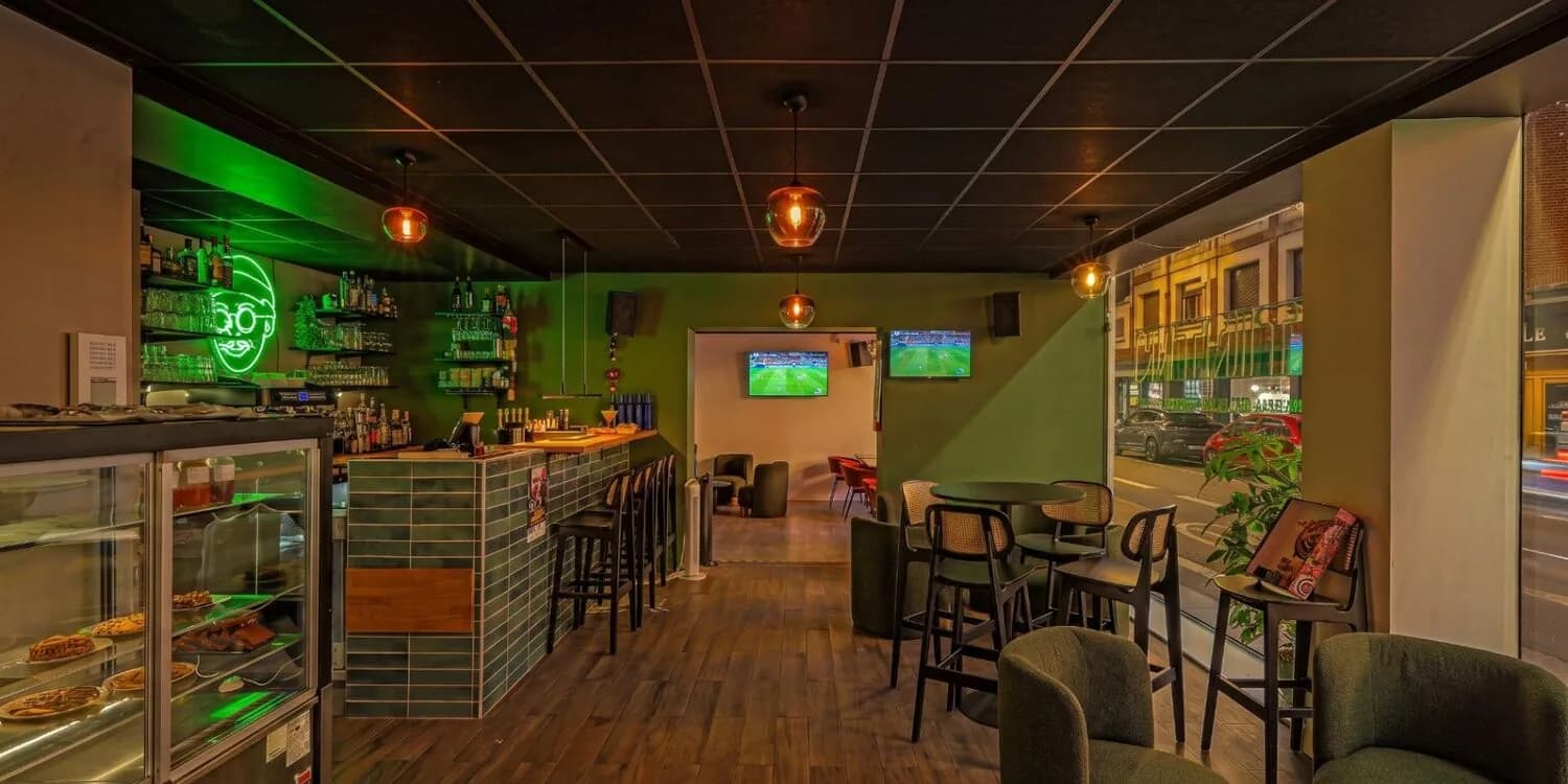 Salle bar avec le comptoir à gauche et le passage vers l'autre salle.